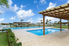 A swimming pool area with a pergola, palm trees, and a white fence. - Sosua Ocean Village Properties by Calisto Stays (Sosúa)
