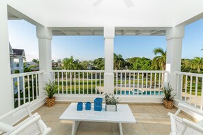 A covered patio with white railings, a table with blue baskets, and potted plants. - Sosua Ocean Village Properties by Calisto Stays (Sosúa)