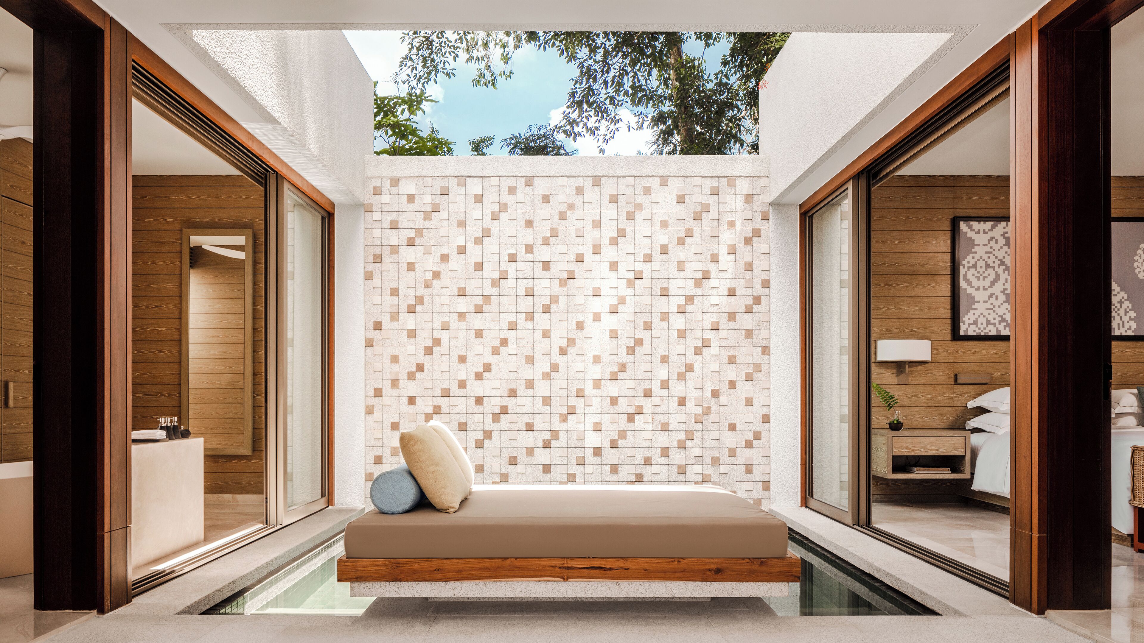 A modern interior with a built-in bench, a tiled wall, and a view of the outdoors.