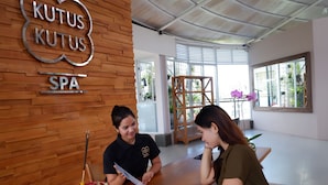 Een receptiegedeelte met een houten wand en een bord waarop 'KUTUS KUTUS SPA' staat.