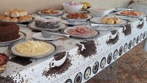 Un tavolo per buffet con diversi cibi, tra cui torte, pasticcini e una grande torta al cioccolato.