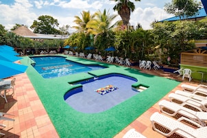 Una piscina al aire libre, sillones reclinables de piscina