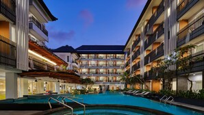 A hotel with a swimming pool, multiple balconies, and a modern architectural design. - Fairfield by Marriott Bali Kuta Sunset Road (Kuta)