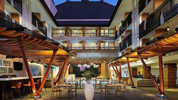 A hotel lobby with a central seating area, multiple balconies, and a reception desk. - Fairfield by Marriott Bali Kuta Sunset Road (Kuta)