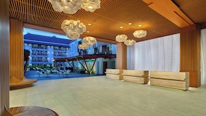 A spacious lobby with a wooden ceiling, modern light fixtures, and a view of the building's exterior. - Fairfield by Marriott Bali Kuta Sunset Road (Kuta)