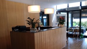 Una cocina moderna con armarios de madera, una isla central, iluminación colgante y vista al área de comedor.