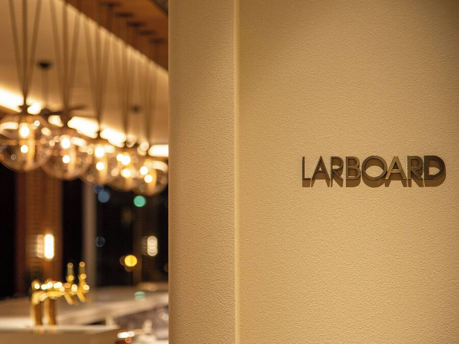 A modern interior with a sign reading "LARBOARD" on a textured wall.