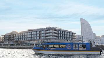 A modern building with a curved facade and a boat docked in front.