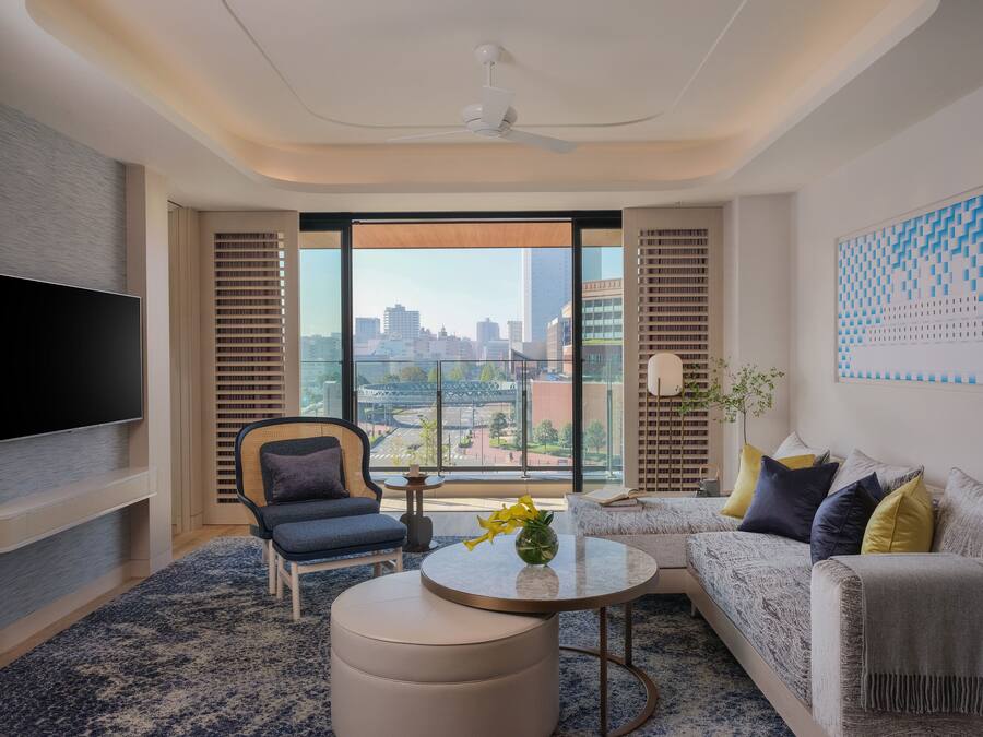 Uma sala de estar moderna com televisão de tela plana, sofá, poltrona e mesa de centro.
