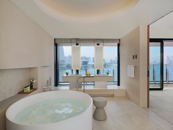 A modern bathroom with a large bathtub, a vanity with a mirror, and a view of the city through large windows. - Intercontinental Yokohama Pier 8 by IHG (Yokohama)