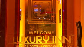 A sign for the Luxury Inn with a welcoming message and a logo.