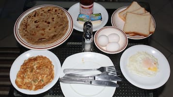 A breakfast table with plates of food, including eggs, toast, and a flatbread.