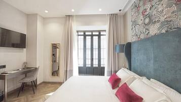 Una habitación de hotel moderna con una cama grande, un escritorio y un televisor.