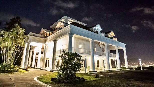 A large, two-story building with a covered porch and columns, surrounded by greenery. - Fogo Resort (San Antonio)