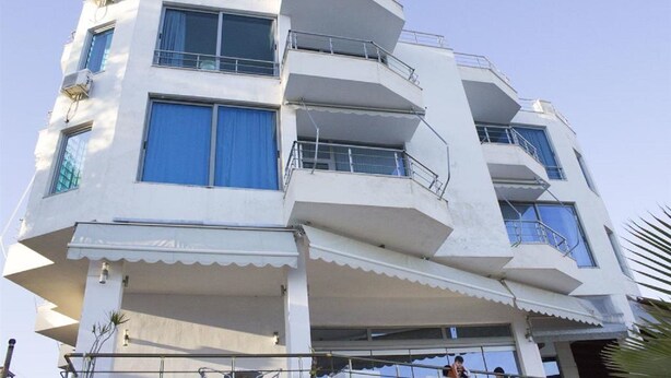 A multi-story building with balconies, large windows, and a flat roof. - Hotel Titania (Sarandë)