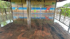A wooden structure with a mural of beach scenes and yoga poses. - Yoga Dreams Negril (Negril)