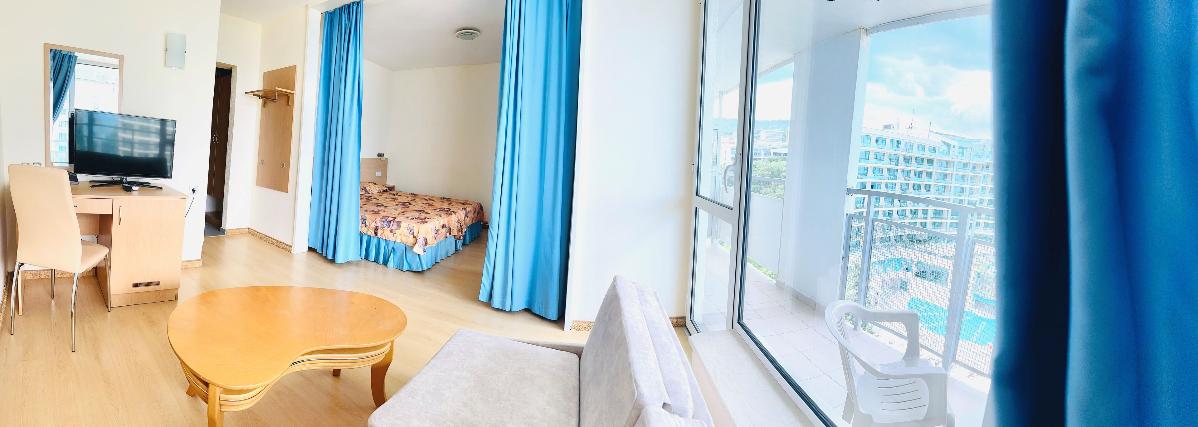 Une chambre d’hôtel avec un lit, un bureau, une télévision et une vue sur le paysage urbain.