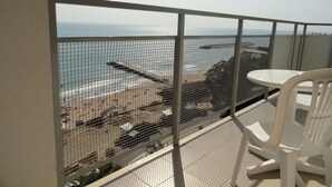 A balcony with a view of the beach, a white table, and a white chair. - Bonita Beach Hotel (Golden Sands)