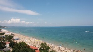 A beach with umbrellas and people, a clear sky, and a calm sea. - Bonita Beach Hotel (Golden Sands)