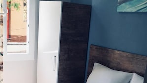 A neatly made bed with a white duvet and pillows, a folded towel, and a wooden headboard. - Hotel Dinlen (Izmir)