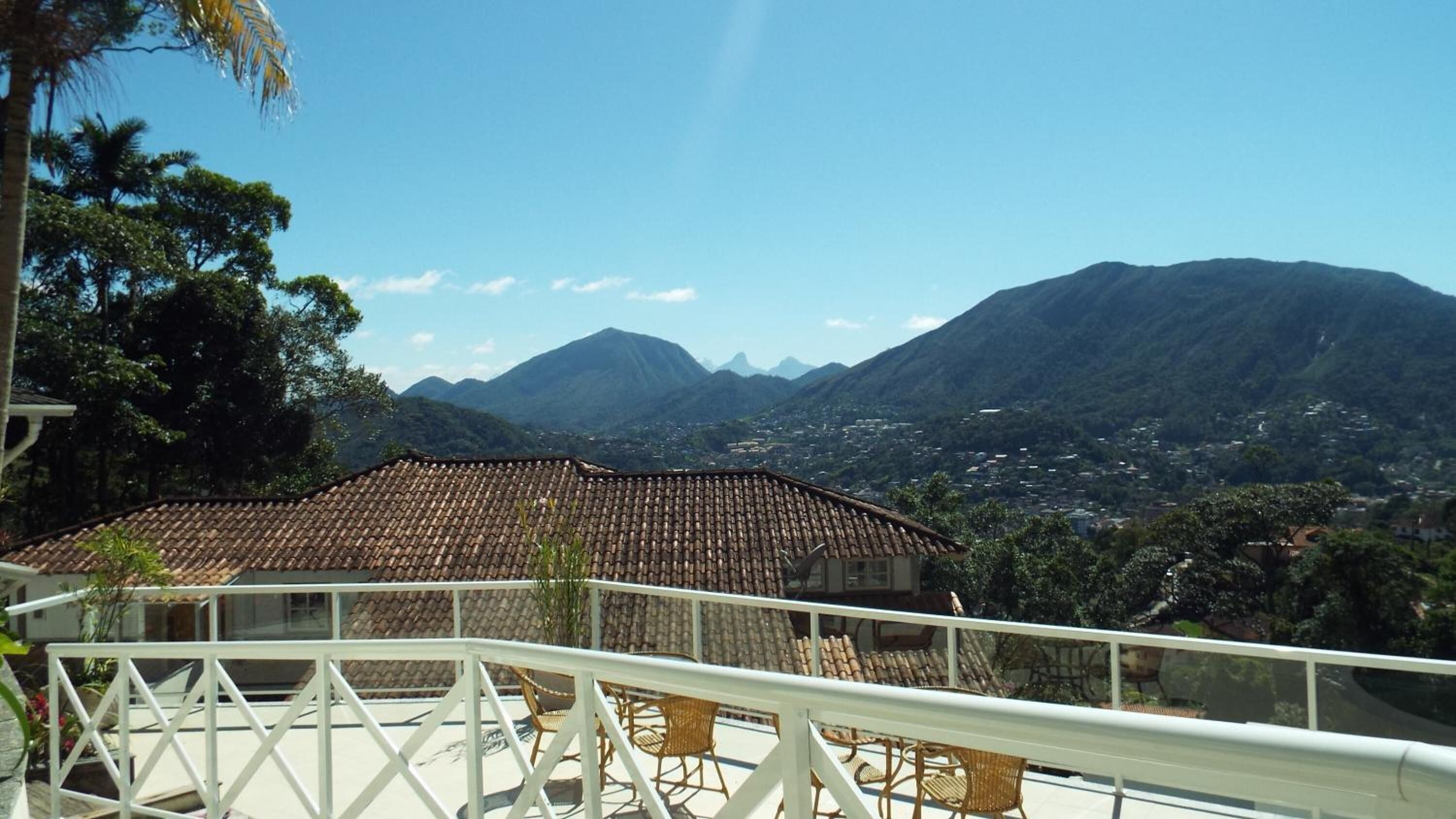A terrace with a view of mountains and a town.