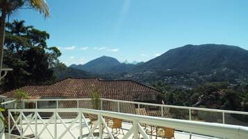 A terrace with a view of mountains and a town.