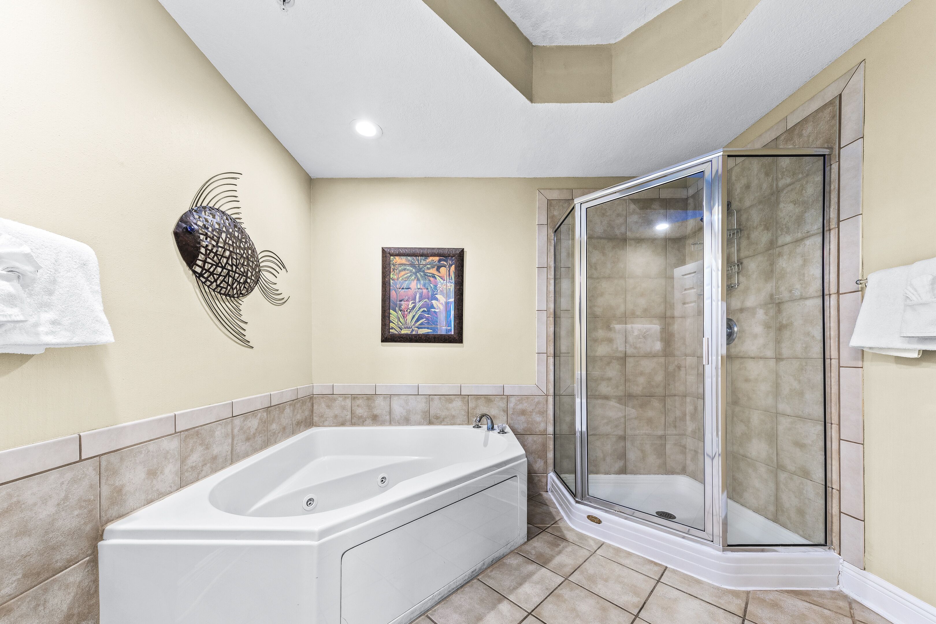 Ein modernes Badezimmer mit freistehender Badewanne, einer Duschkabine aus Glas und dekorativen Wandbildern.