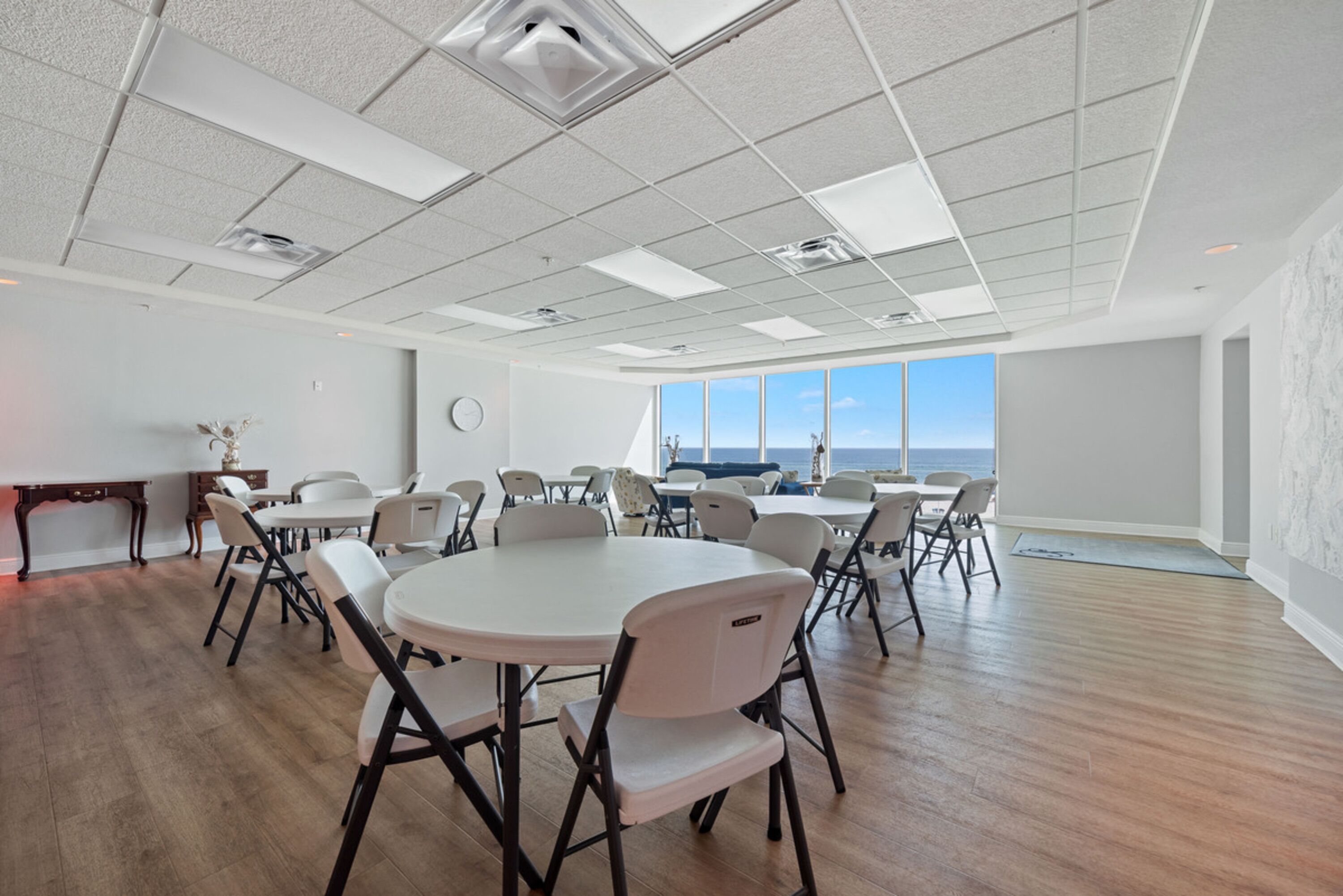 Ein geräumiger Konferenzraum mit hoher Decke, großen Fenstern und Meerblick.