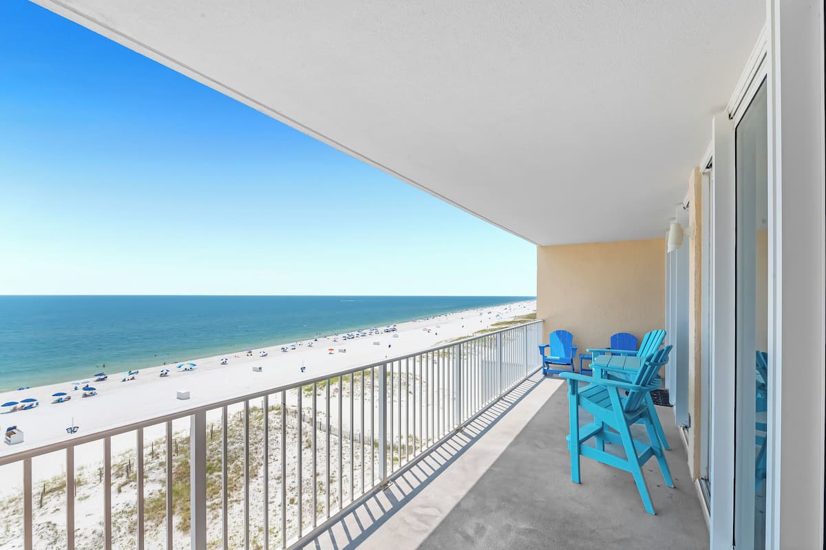 Un balcon avec vue sur une plage et l’océan.