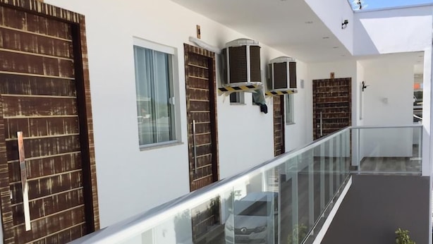 Ein modernes Wohngebäude mit Glasbalkon, großen Fenstern und einem klaren, minimalistischen Design.