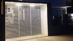 Ein modernes, zweistöckiges Haus mit großer Garagentür und gut beleuchteter Fassade.