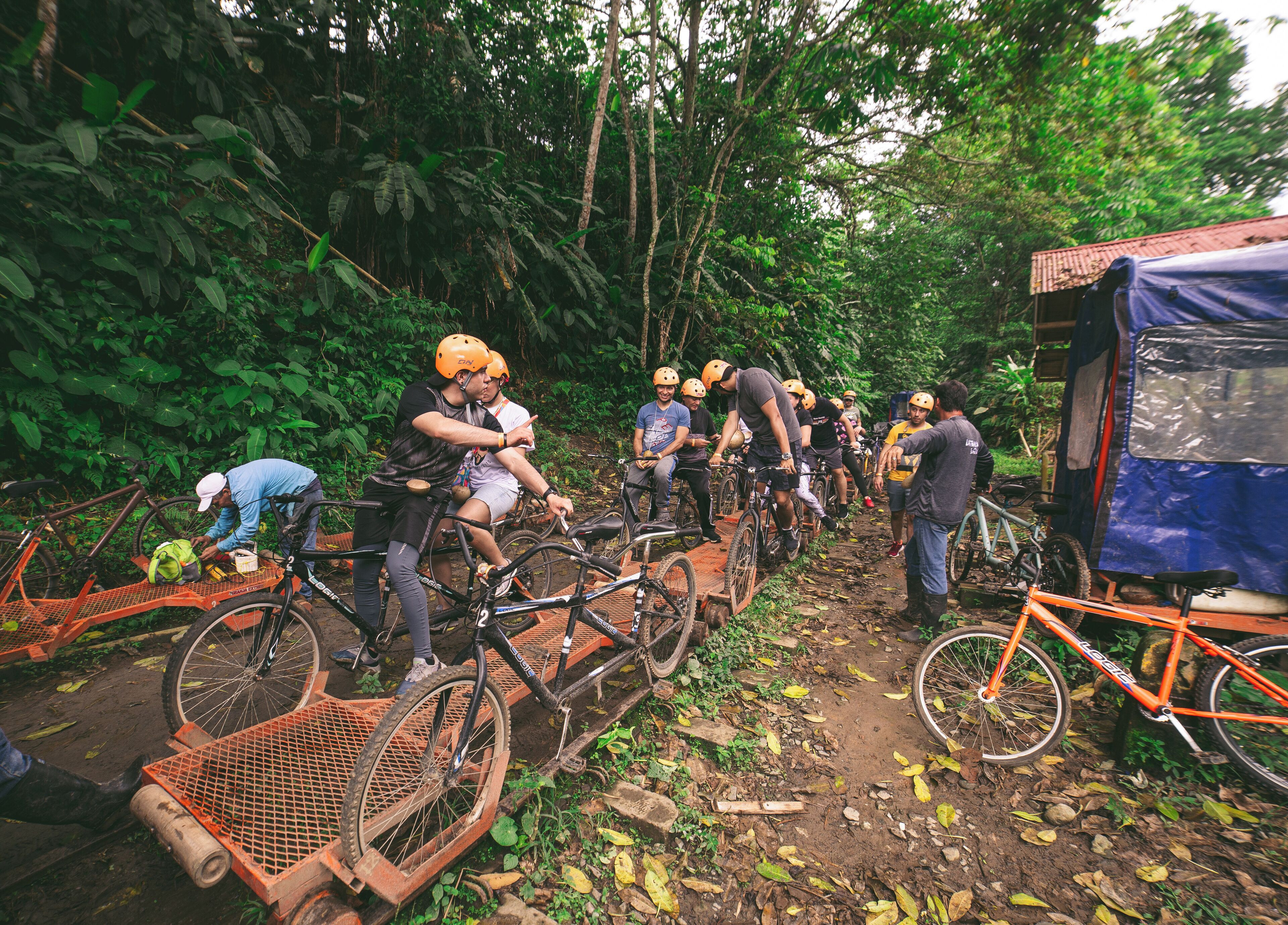 Un grupo de ciclistas en un sendero de tierra rodeado de abundante follaje.