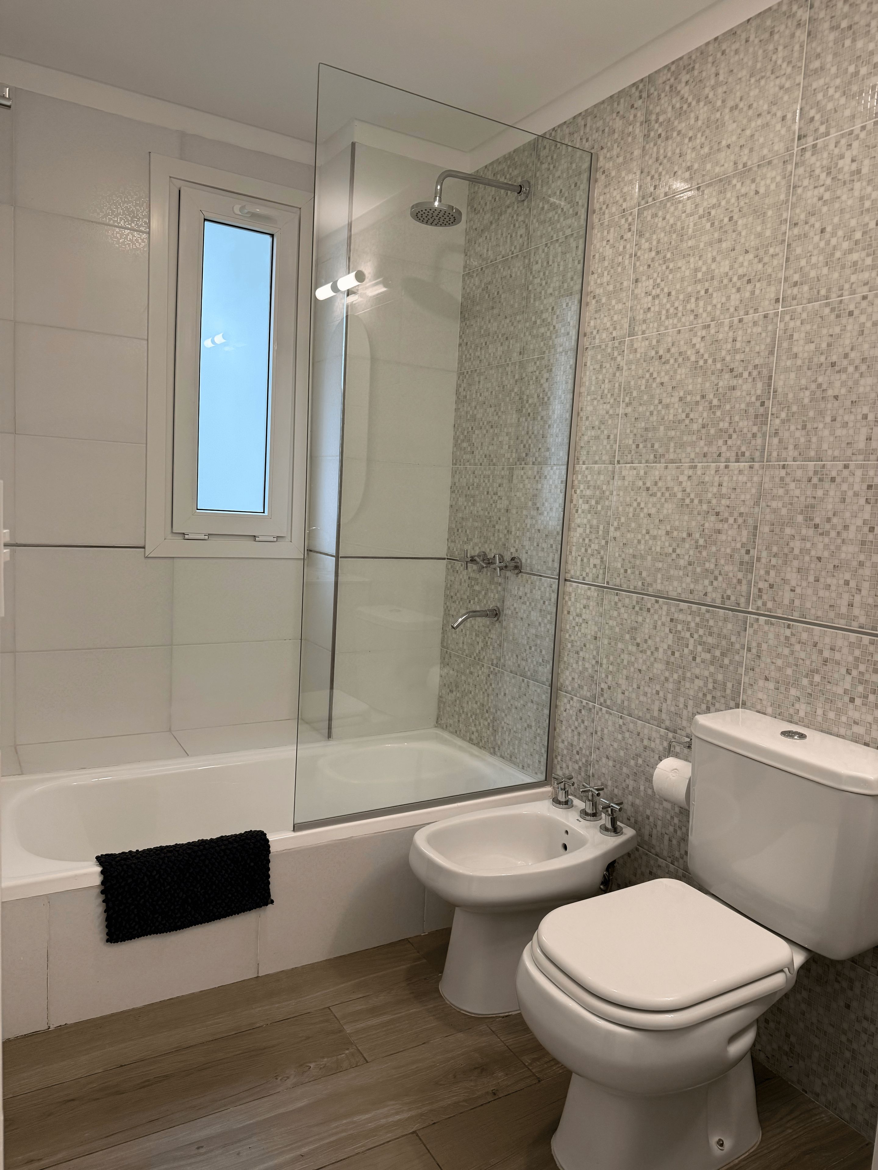 A bathroom with a bathtub, a shower, a bidet, and a toilet.