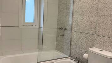 A bathroom with a bathtub, a shower, a bidet, and a toilet.