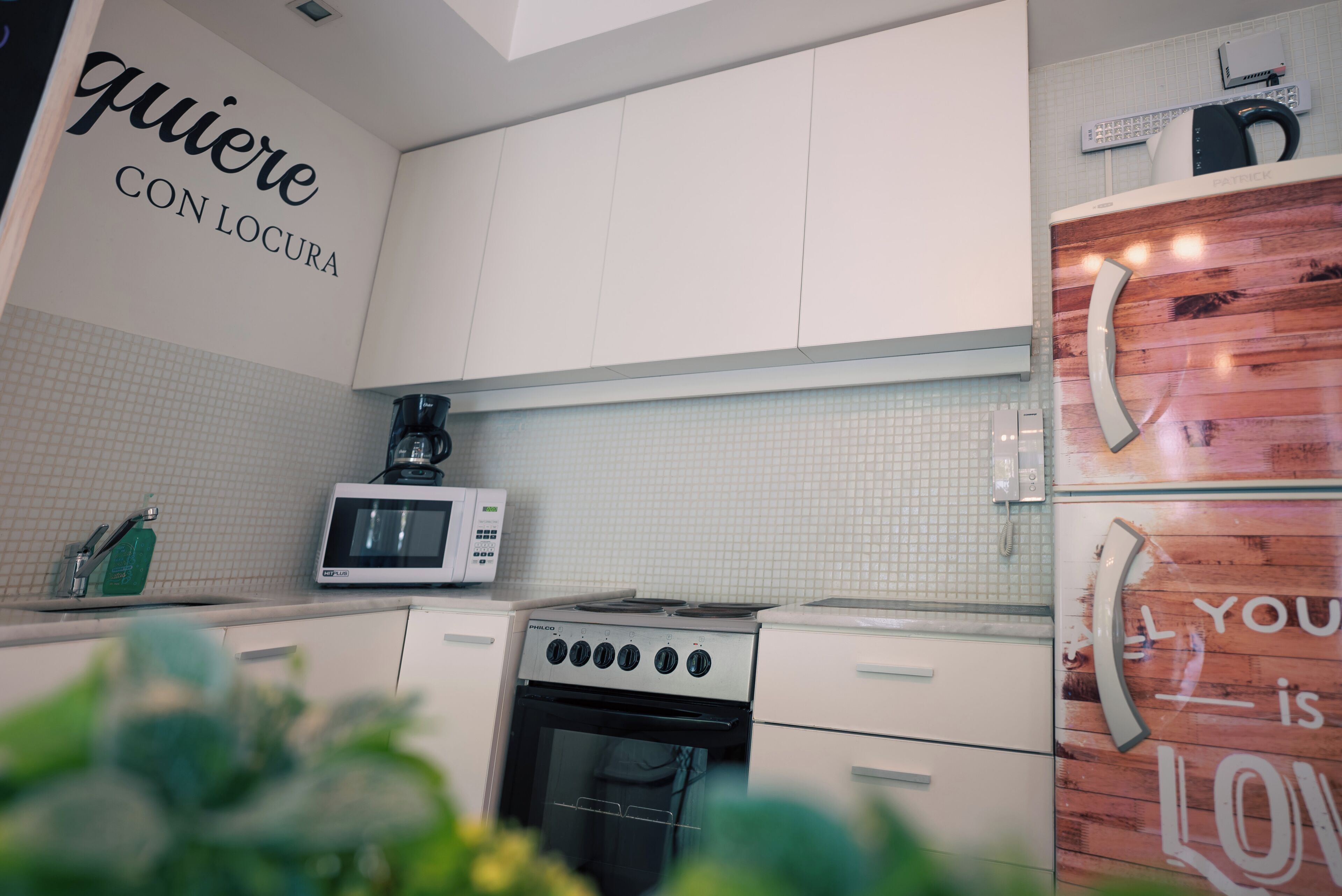 A kitchen with white cabinets, a microwave, a stove, and a refrigerator.