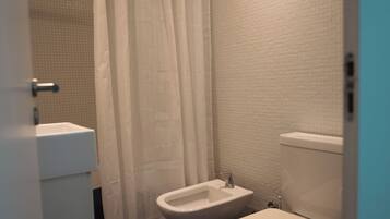 Et badeværelse med toilet, bidet og håndvask.