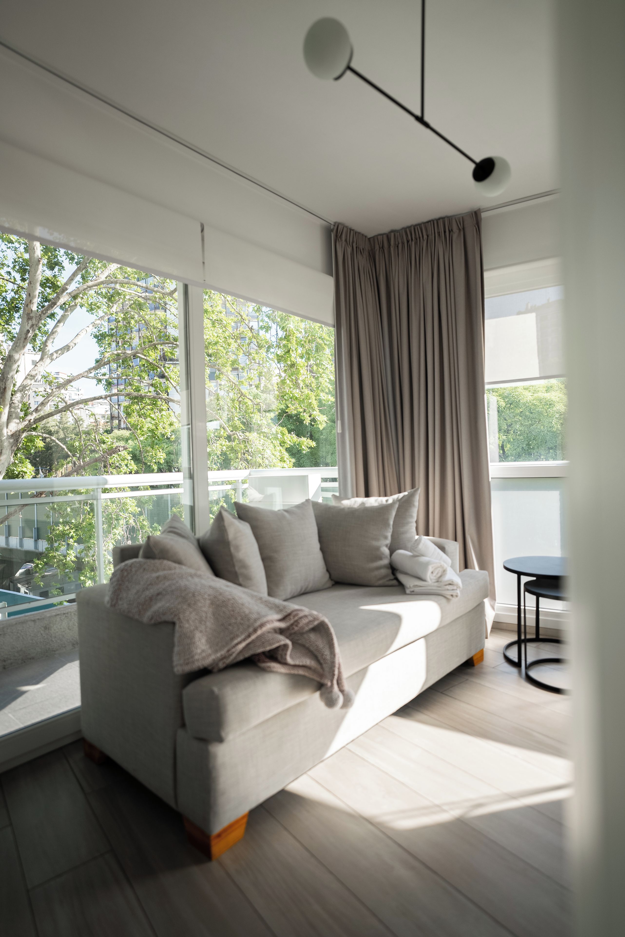Un salón moderno con un sofá, una mesita y vistas a zonas verdes.