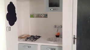 A compact kitchen with a gas stove, a sink, and a cabinet. - Bnb Dragonetti (Manduria)