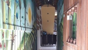 A narrow hallway with a tiled floor, wooden walls, and a ceiling with exposed beams. - Hotel La Cosecha (Pereira)