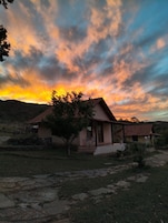 Una casa con techo de tejas, un porche con sillas y un camino de piedra que conduce a la entrada.