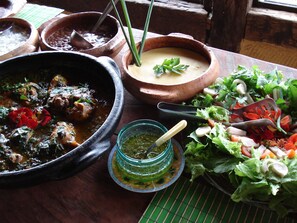 Variedad de platos, incluyendo un guiso, una sopa y una ensalada, que sugieren una amplia selección de comidas.