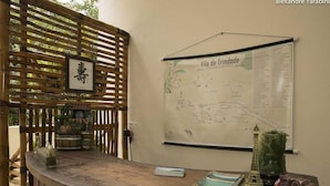 A wooden table with a map, a small Eiffel Tower model, and a green vase. - Pousada Colibri (Paraty)