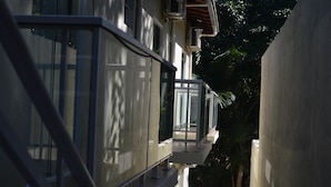 A modern building with a glass balcony and a concrete wall. - Pousada Colibri (Paraty)