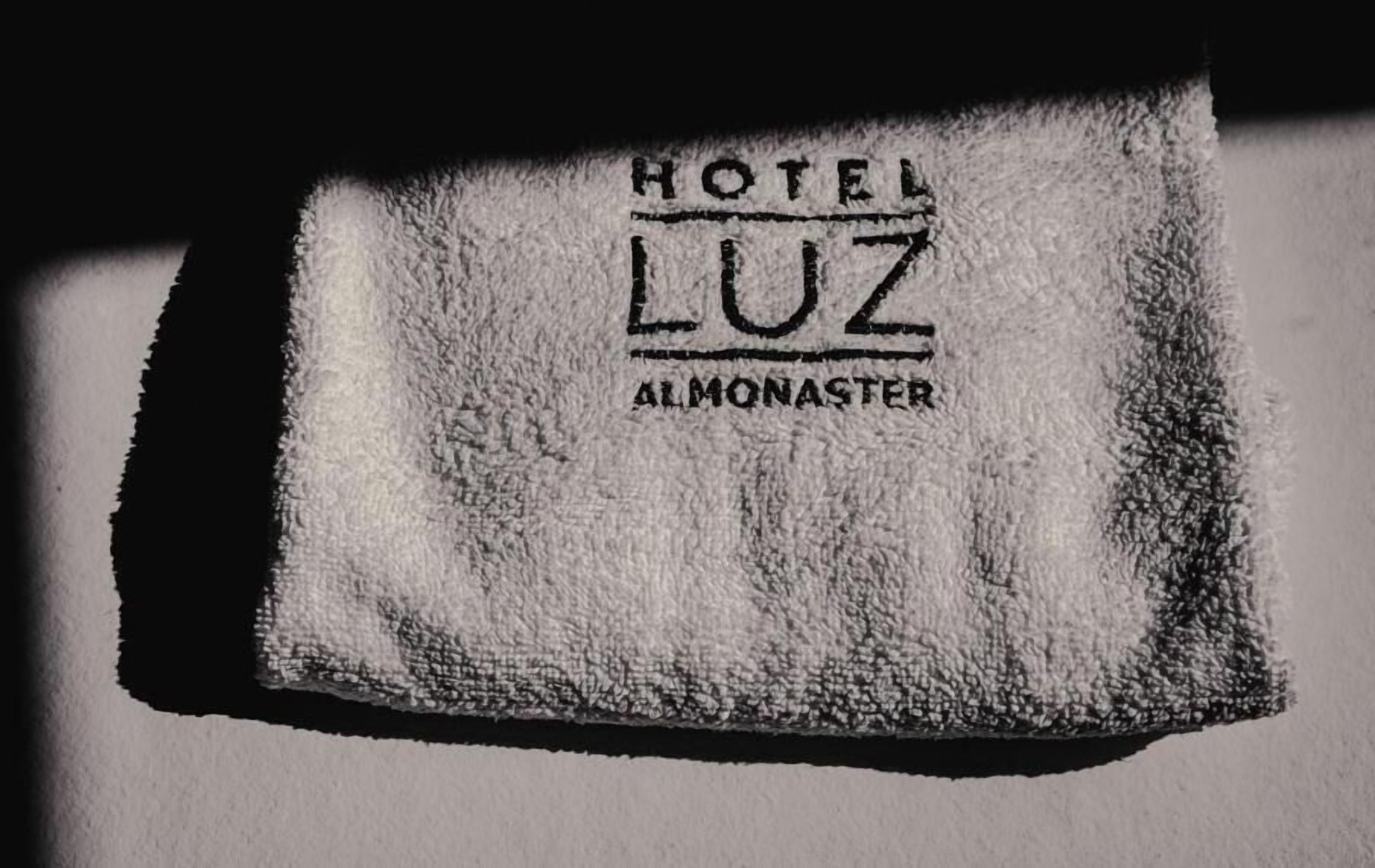 Una toalla con la leyenda 'HOTEL LUZ ALMONASTER' impresa.