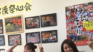 Two people sitting at a table with posters on the wall behind them. - Heart Hostel and Diner (Ise)