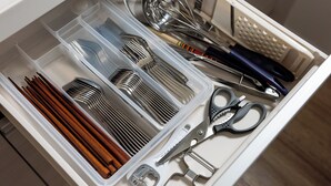 A drawer with utensils, including spoons, forks, and chopsticks, as well as a pair of scissors and a bottle opener. - Tsukasa Condo Chatan Araha (Chatan)