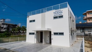 A modern building with a sign reading "Condo Tsukasa Chatan Araha". - Tsukasa Condo Chatan Araha (Chatan)