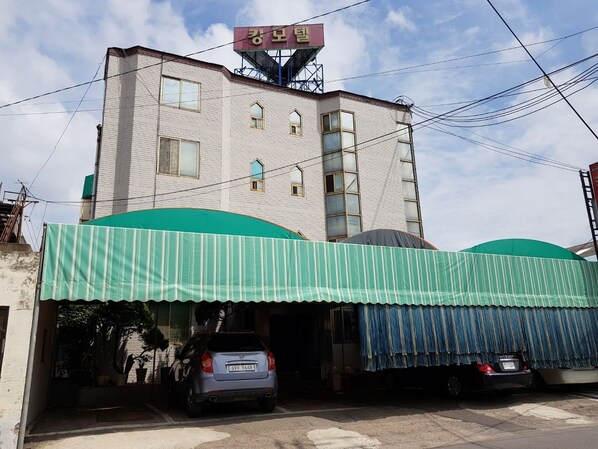 A building with a green awning and a sign above the entrance.