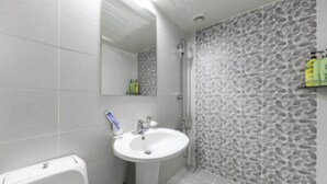 A bathroom with a white sink, a mirror, and a shower. - Gunsan King Motel (Gunsan)