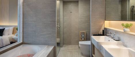 A modern bathroom with a large bathtub, a separate shower area, and a toilet.